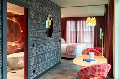 a hotel room with a bed and a table and chairs at Nhow Lima in Lima