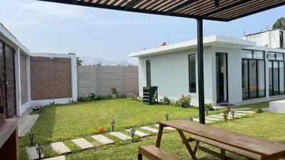 a backyard with a wooden bench and a house at Casa de Campo Aucallama in Huaral