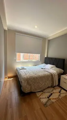 a bedroom with a bed and a window and a rug at Casa de Campo Aucallama in Huaral
