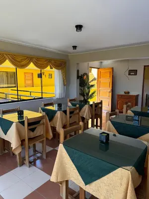 a restaurant with tables and chairs and a balcony at Hotel Alicia in El Puente