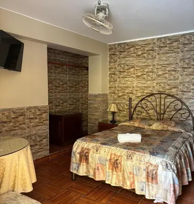 a bedroom with a bed and a brick wall at Hotel Alicia in El Puente