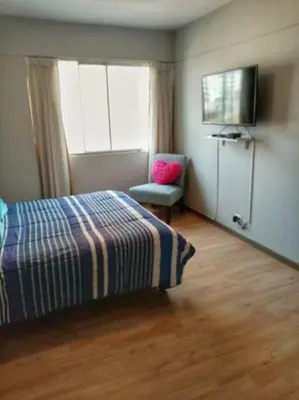 a bedroom with a bed and a chair and a television at Bonito y Moderno 1 o 2 dormitorios in Lima