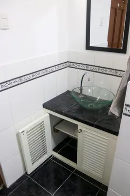 a bathroom with a green sink and a mirror at Hermosa habitación independiente cerca a Miraflores in Lima