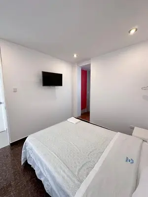 a bedroom with a bed and a tv on a wall at Hotel Atenas City in San Andrés