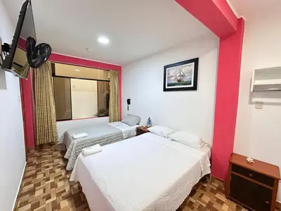 two beds in a room with red and white walls at Hotel Atenas City in San Andrés