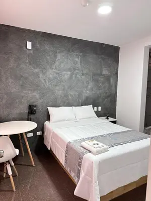 a bedroom with a large bed and a table at Hotel Atenas City in San Andrés