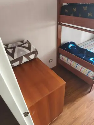 a room with a bunk bed and a wooden drawer at Adriane in Lima