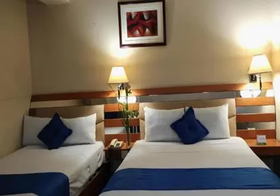 two beds in a hotel room with blue pillows at Blue Star Hotel in Lima