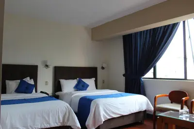 a hotel room with two beds and a window at Blue Star Hotel in Lima