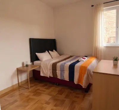 a small bedroom with a bed and a table at Aqquazul Hospedaje Ayacucho in Ayacucho