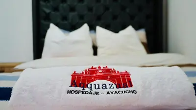 a white towel with a train on top of a bed at Aqquazul Hospedaje Ayacucho in Ayacucho