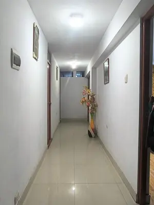 a long hallway with a vase of flowers in it at Aqquazul Hospedaje Ayacucho in Ayacucho