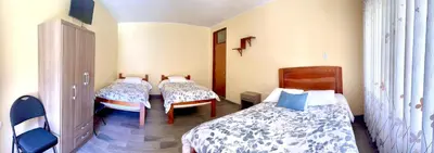 a room with three beds in a room at DCampos Lodge in Oxapampa