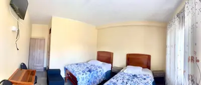 a bedroom with two beds and a table at DCampos Lodge in Oxapampa