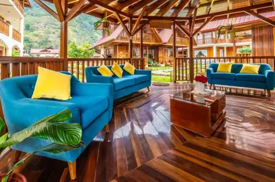 a living room with blue couches and a table at DCampos Lodge in Oxapampa