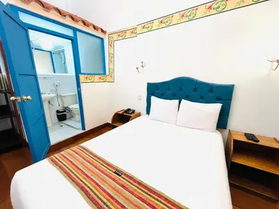a bedroom with a bed and a blue door at Rojas Plaza Boutique in Cusco