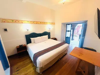 a bedroom with a large bed and a wooden floor at Rojas Plaza Boutique in Cusco