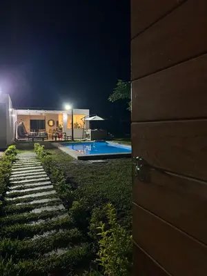 a house with a swimming pool at night at Casa de campo en Condominio in San Vicente de Cañete
