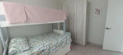 a small bedroom with a bunk bed with a bedspread at Casa de campo en Condominio in San Vicente de Cañete