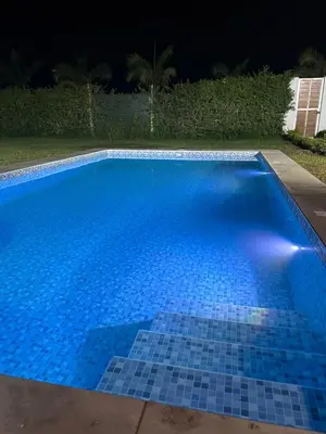 a blue tile swimming pool at night at Casa de campo en Condominio in San Vicente de Cañete