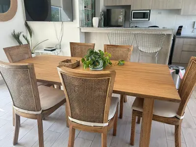 a wooden dining room table with chairs and a kitchen at Casa de campo en Condominio in San Vicente de Cañete