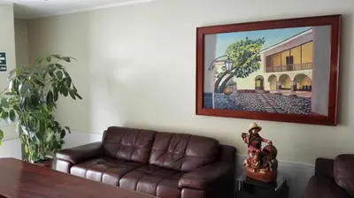 a living room with a couch and a painting on the wall at Hotel Rivera in Ayacucho