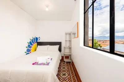 a bedroom with two beds and a large window at Retablo Boutique Hotel in Ayacucho