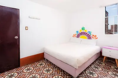 a white bedroom with a bed and a window at Retablo Boutique Hotel in Ayacucho