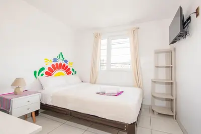 a white bedroom with a bed and a window at Retablo Boutique Hotel in Ayacucho