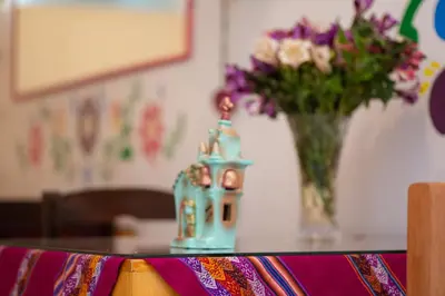 a table with a vase of flowers on top of it at Retablo Boutique Hotel in Ayacucho
