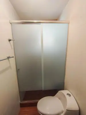 a bathroom with a toilet and a glass shower at Cusco Central Complete Apartment in Cusco