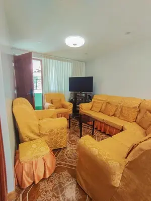 a living room with yellow furniture and a flat screen tv at Cusco Central Complete Apartment in Cusco