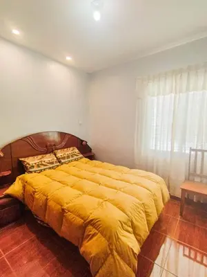 a bedroom with a large bed with a yellow blanket at Cusco Central Complete Apartment in Cusco