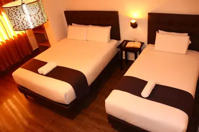 a hotel room with two beds and a table at Tikal Inn Machupicchu in Machu Picchu