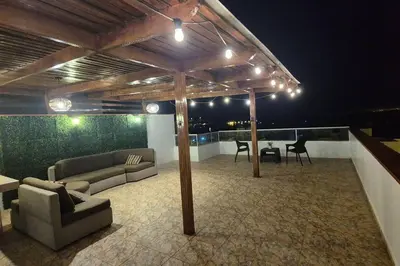 a patio with couches and a table on a roof at Apartamento duplex a 1 cuadra de Playa Naplo in Pucusana