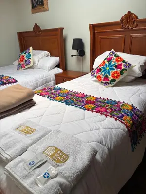 two beds in a room with confetti on them at Rumiwasi Inn Apartament in Ollantaytambo