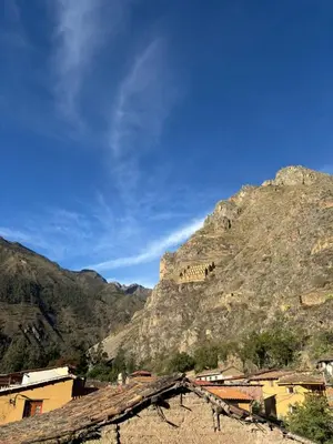 a view of a mountain with a building on it at Rumiwasi Inn Apartament in Ollantaytambo