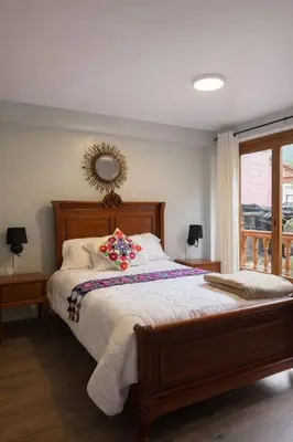 a bedroom with a large bed with flowers on it at Rumiwasi Inn Apartament in Ollantaytambo