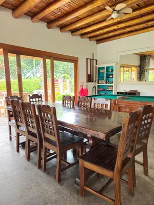a dining room with a large wooden table and chairs at Alquiler Casa de Campo Asia Cañete in San Andrés