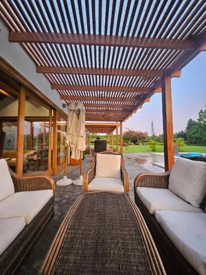 a patio with wicker chairs and a wooden pergola at Alquiler Casa de Campo Asia Cañete in San Andrés