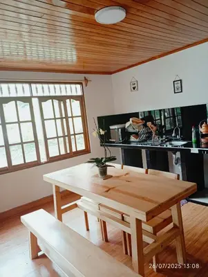 a kitchen with a wooden table and a dining room at Casa Las Palmeras in Oxapampa