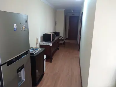 a hallway of a room with a refrigerator and a microwave at Departamento Centro Financiero San isidro in Lima
