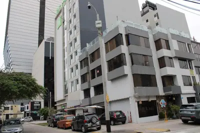 a tall white building with cars parked in front of it at Departamento Centro Financiero San isidro in Lima
