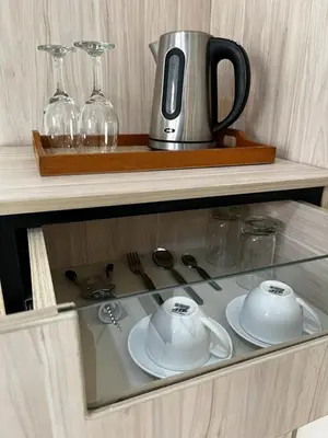 a glass shelf with a tea pot and glasses on it at Residencial Mar Caribe in Lima