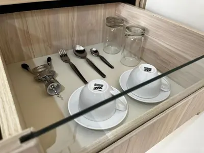 a glass cabinet with two plates and utensils at Residencial Mar Caribe in Lima