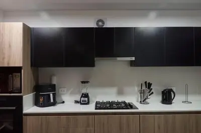 a kitchen with black cabinets and a counter top at Departamento de Estreno Lima Miraflores in Lima
