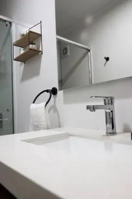 a white bathroom with a sink and a mirror at Departamento de Estreno Lima Miraflores in Lima