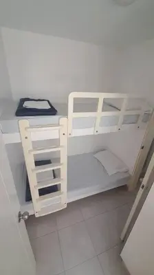 a small white bunk bed in a room at Gaviotas de Paracas in Paracas