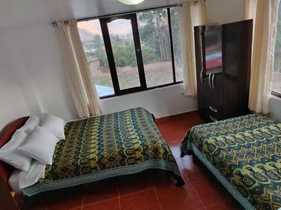 a bedroom with a bed and a large window at Casa de Campo Apu San Isidro in Urubamba