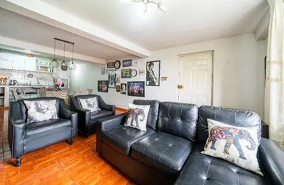a living room with a black leather couch and chairs at Lopez House Family Aparment in Lima